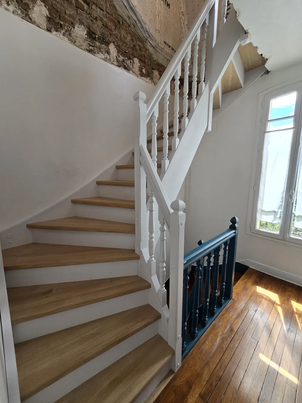Escalier quart tournant laqué blanc à balustres tournés et marches en bois